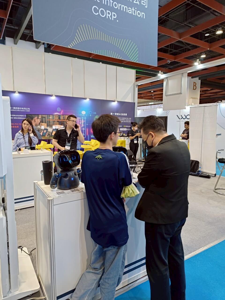 AI WAVE SHOW 2025の来場者が、デスクトップ型のKebbiロボットと対話しています。