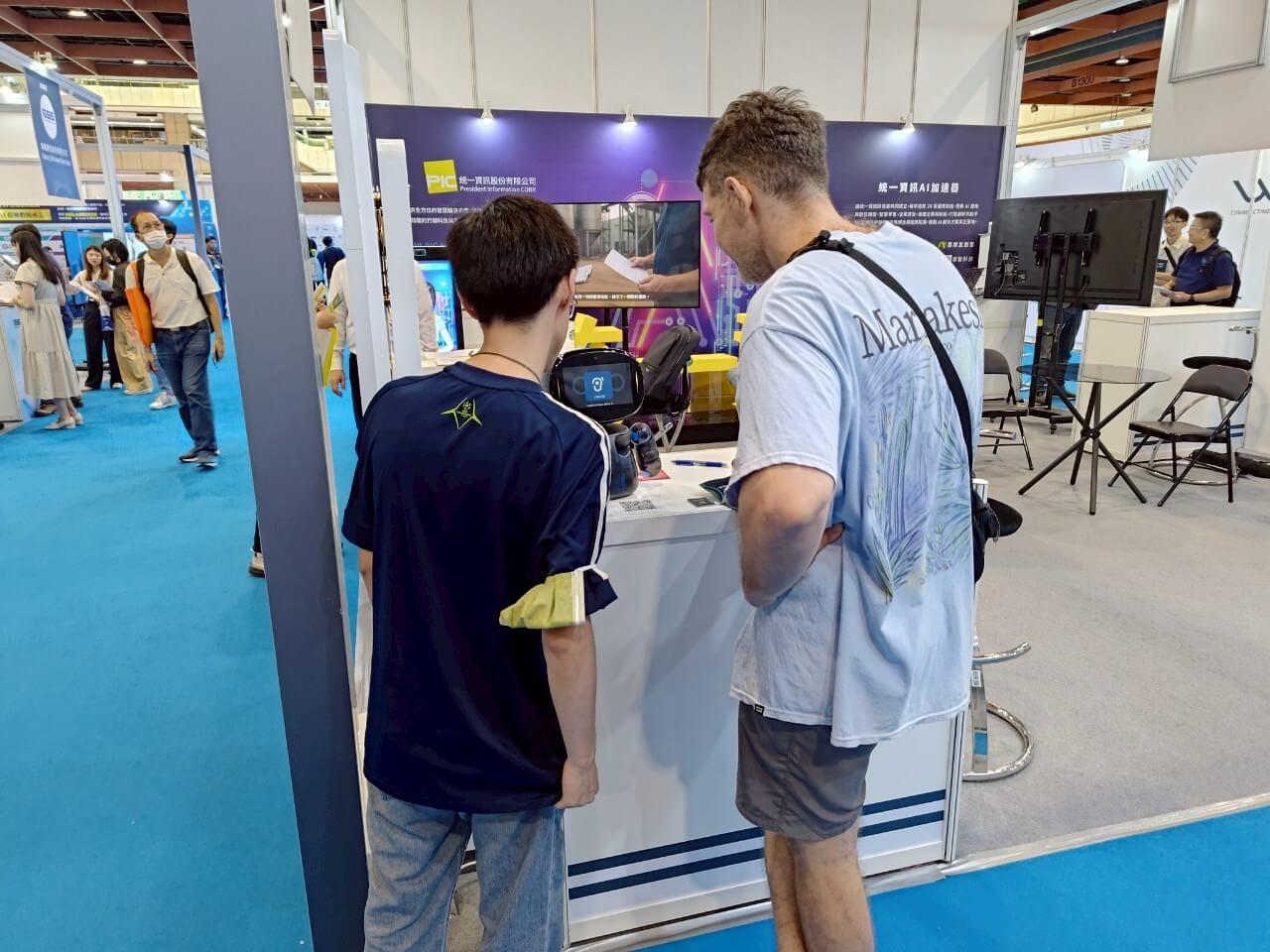 海外からの来場者が、AI WAVE SHOW 2025のブースでKebbiロボットを体験しています。